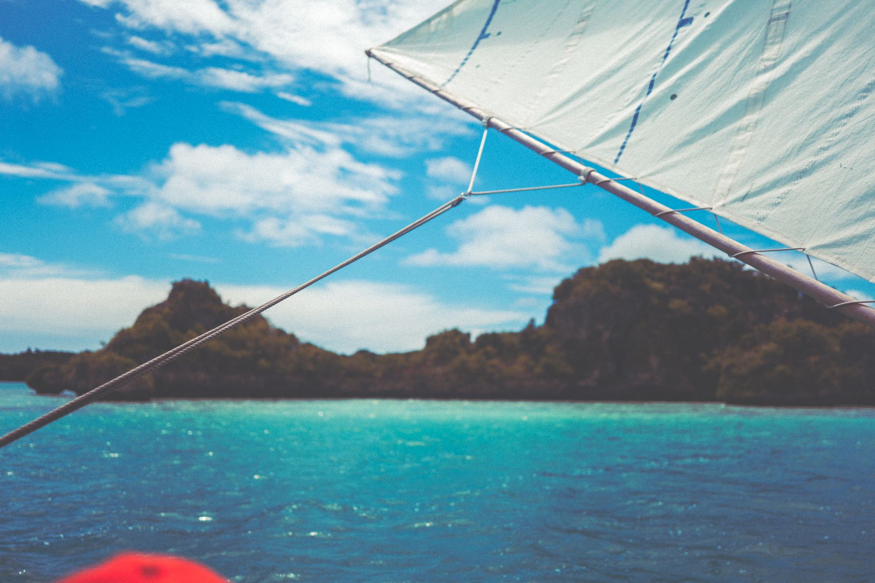La voile de la pirogue prend le vent. L'eau est turquoise. On passe à coté des roches qui sortent de l'eau