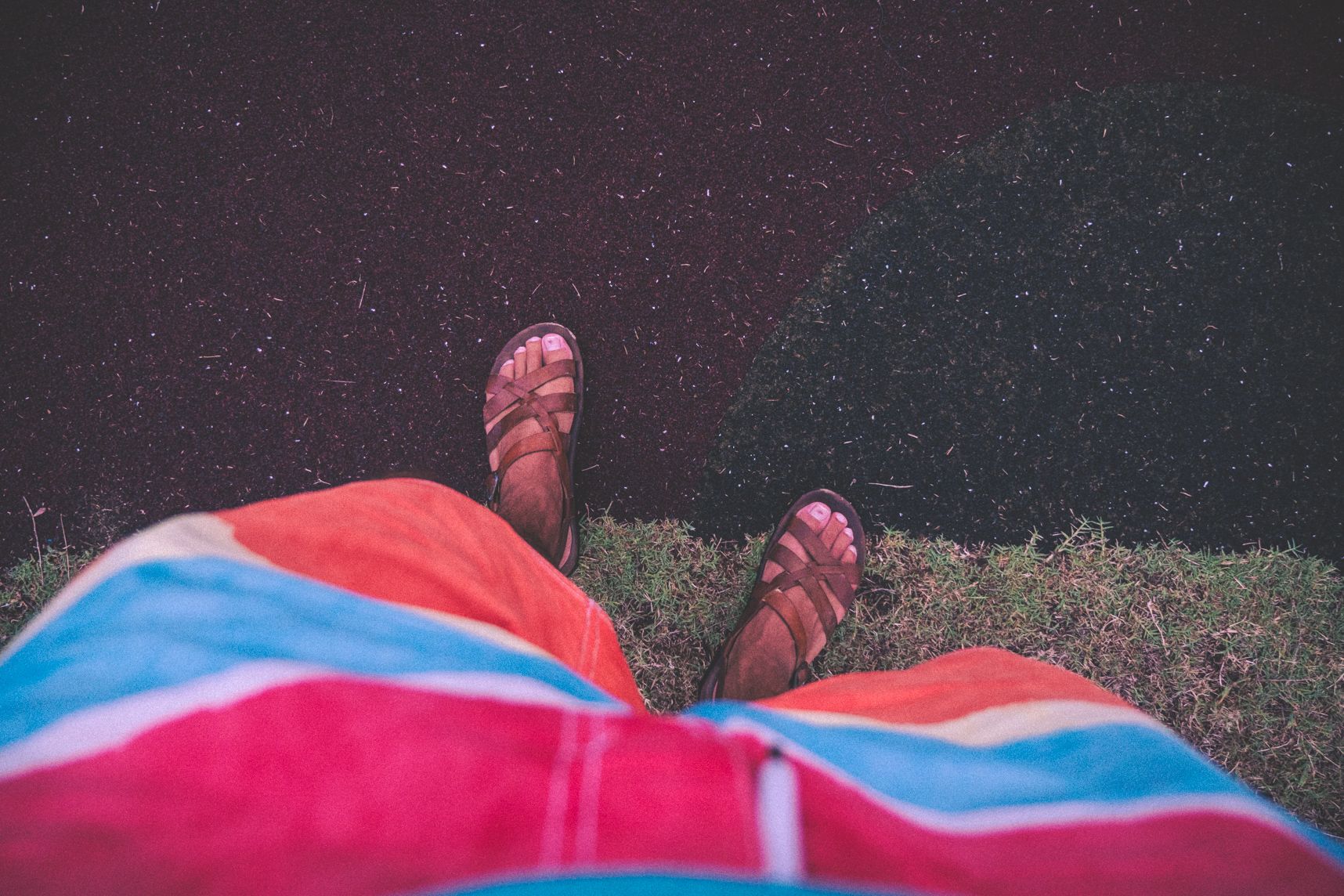 Des pieds à la limite entre le gazon et l'air de jeu