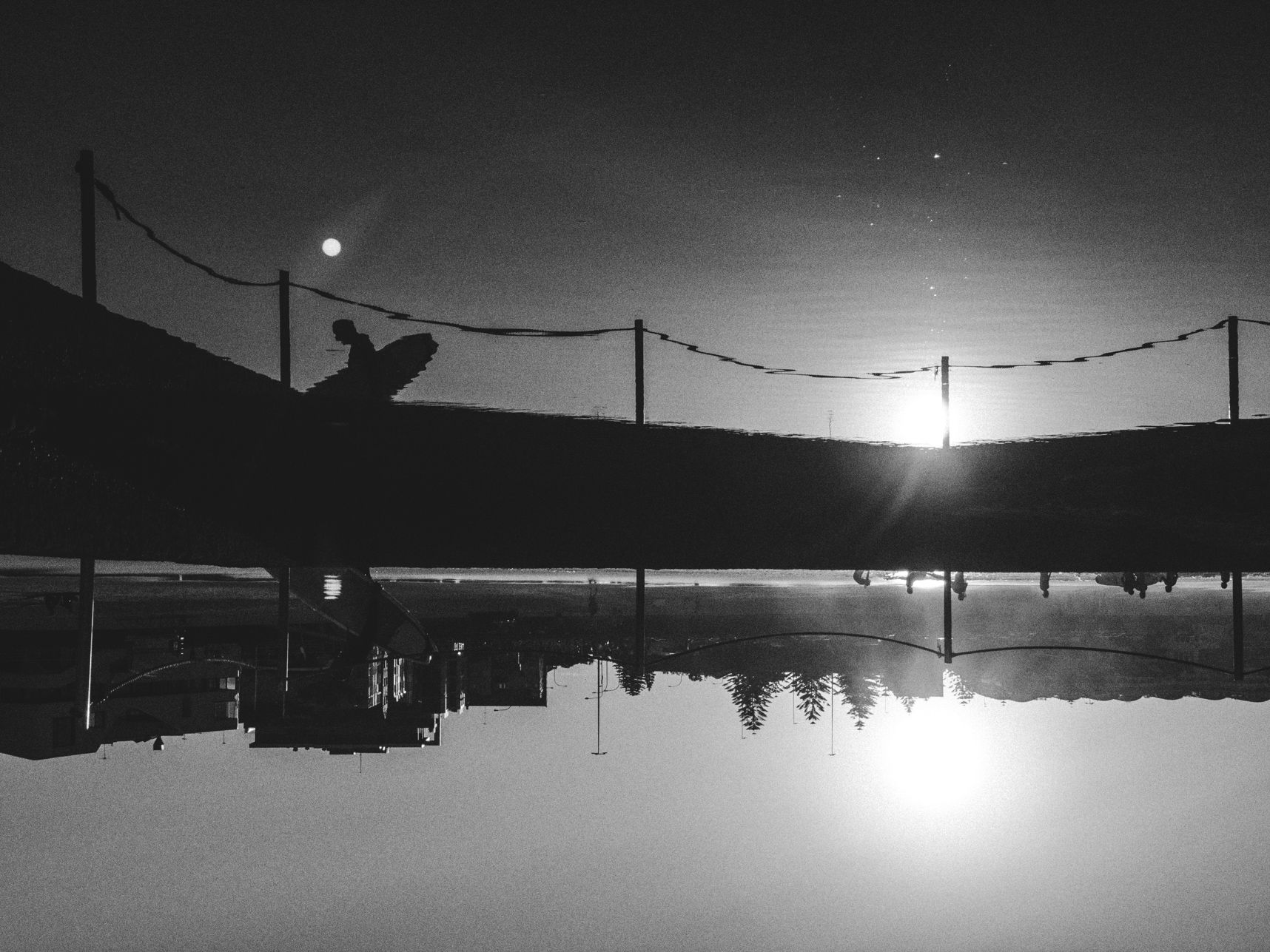Reflet de coucher de soleil en noir et blanc sur la piscine de Bondi Beach. Le ciel est en bas, la piscine en haut
