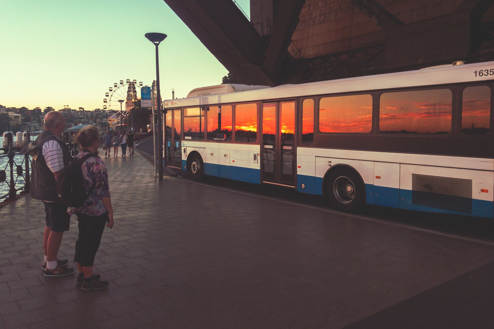 Sous le Harbour Bridge de Sydney le bus reflète le coucher de soleil dans ses vitres