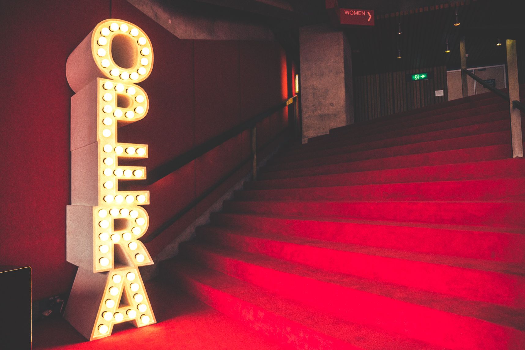 Le tapis rouge de l'opéra de Sydney et le mot opéra écrit avec différentes ampoules