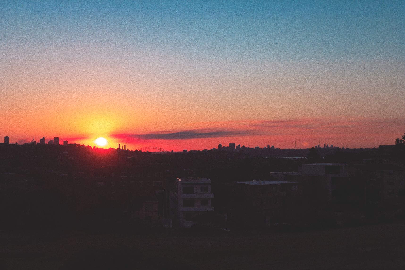 Coucher de soleil sur Sydney vu de la colline du golf de Bondi. Le ciel est un beau dégradé du orange vers le bleu