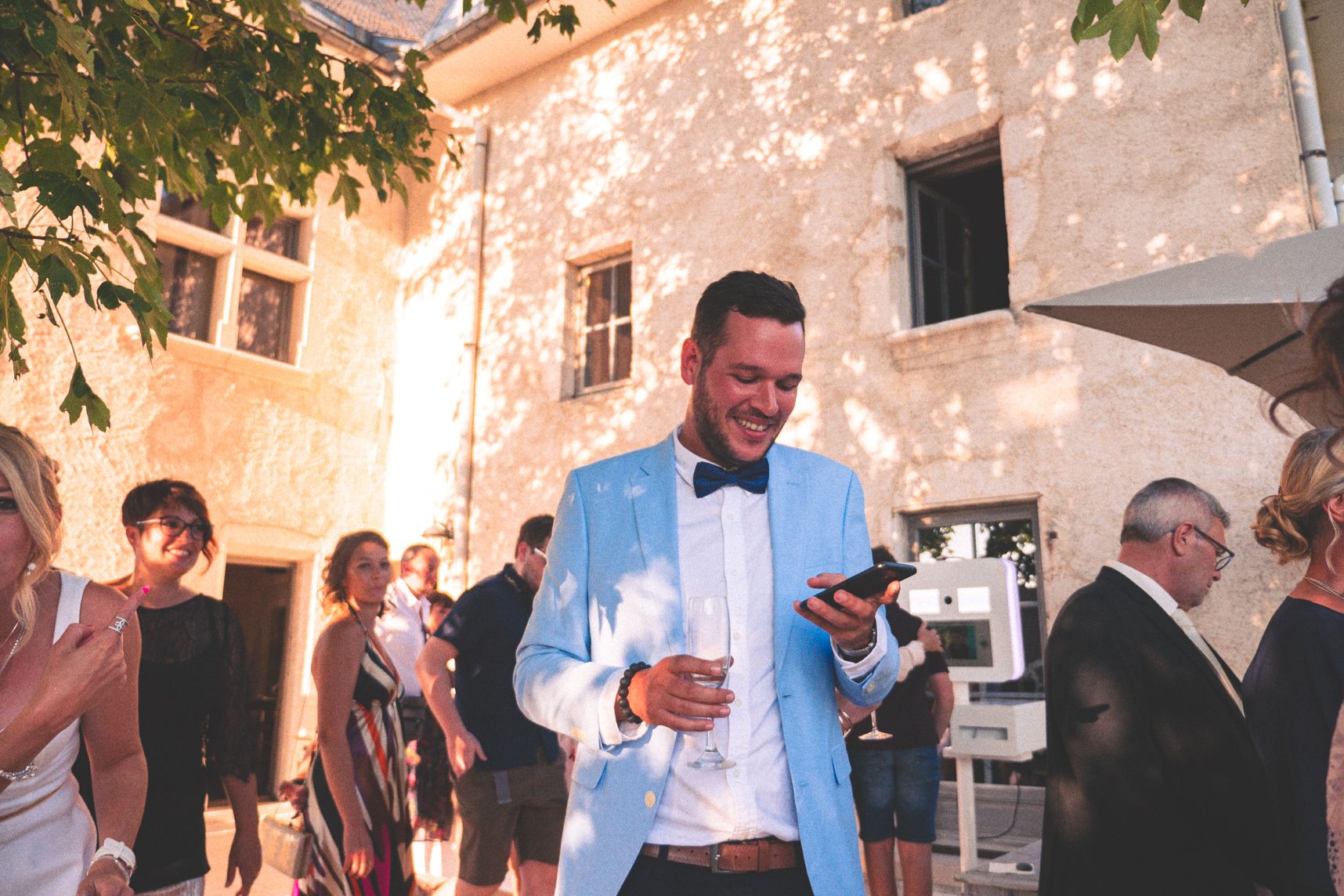 Le vin d'honneur au mariage, tout le monde discute, au milieu un jeune homme tout sourire