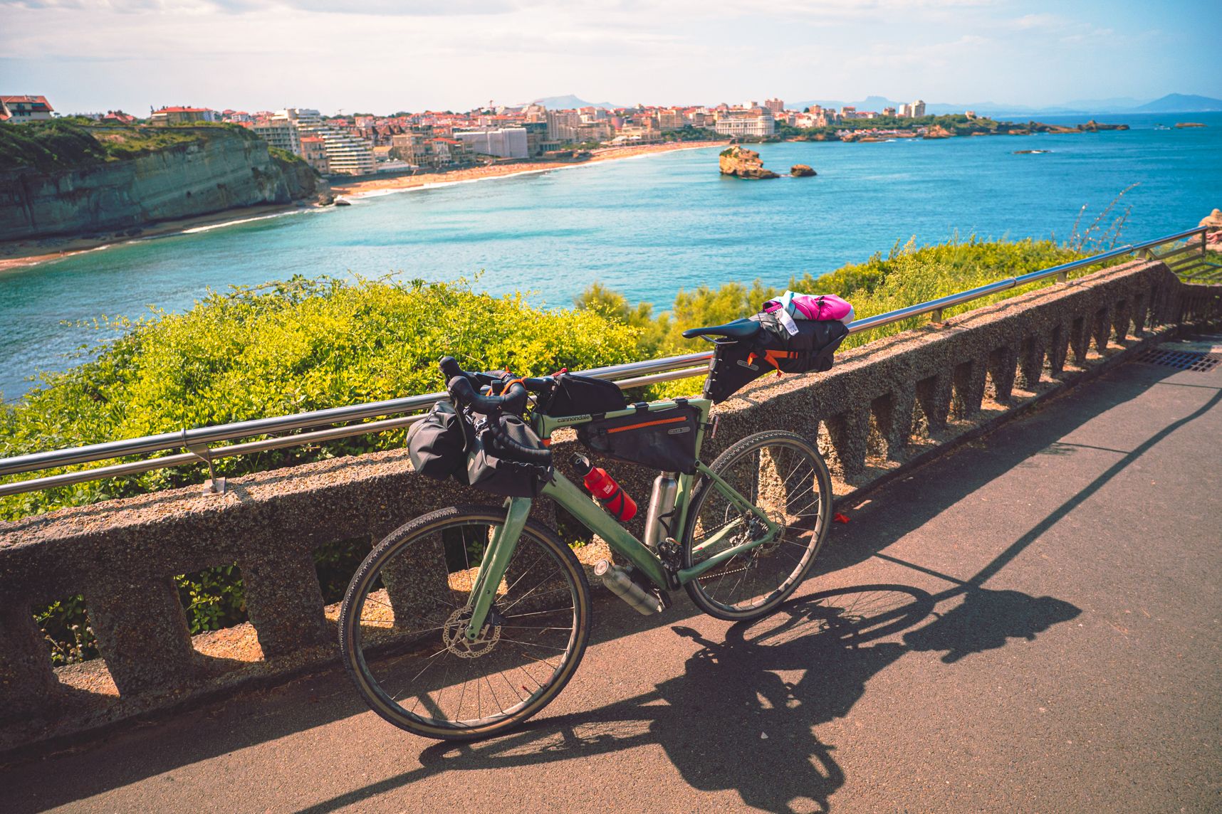 Vue de Biarritz depuis son phare. On y voit sa plage et ses immeubles sous le beau temps. En premier plan mon vélo chargé avec les affaires de bikepacking