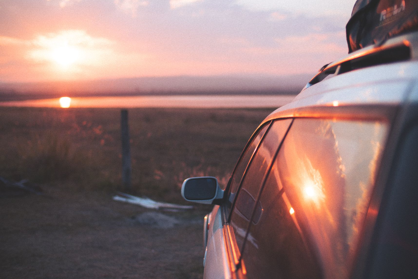 Ma voiture, Lilwenn, regarde le coucher de soleil sur le lac, sur les vitres le coucher de soleil reflète 