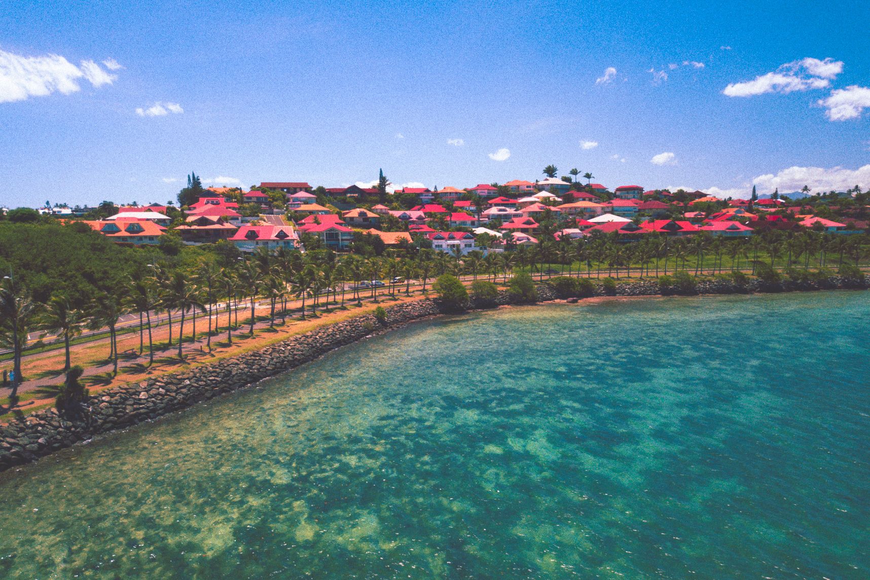Vue de la mer des maisons de Tuband à Nouméa, elles ont toutes un toit rouge