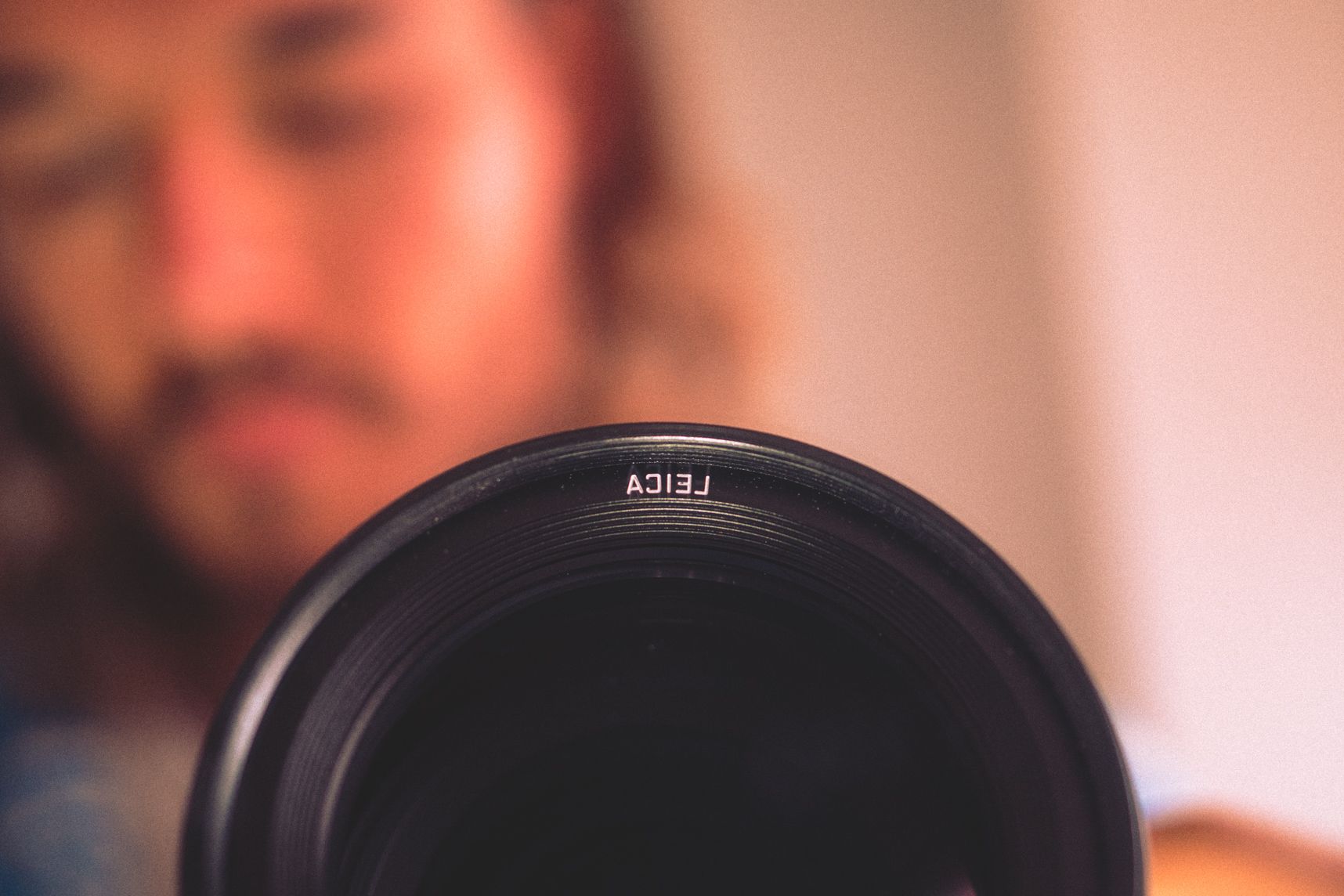 On voit la moitié d'un objectif dans le miroir, le photographe en arrière plan est flou