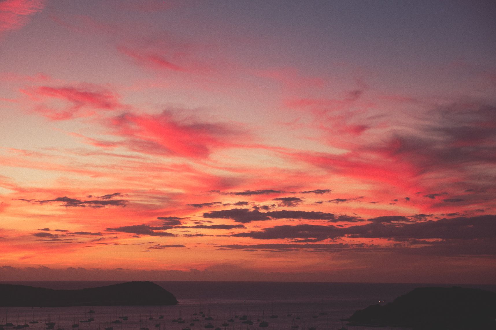 Le coucher de soleil peinturlure les nuages de couleur orangées et rosées
