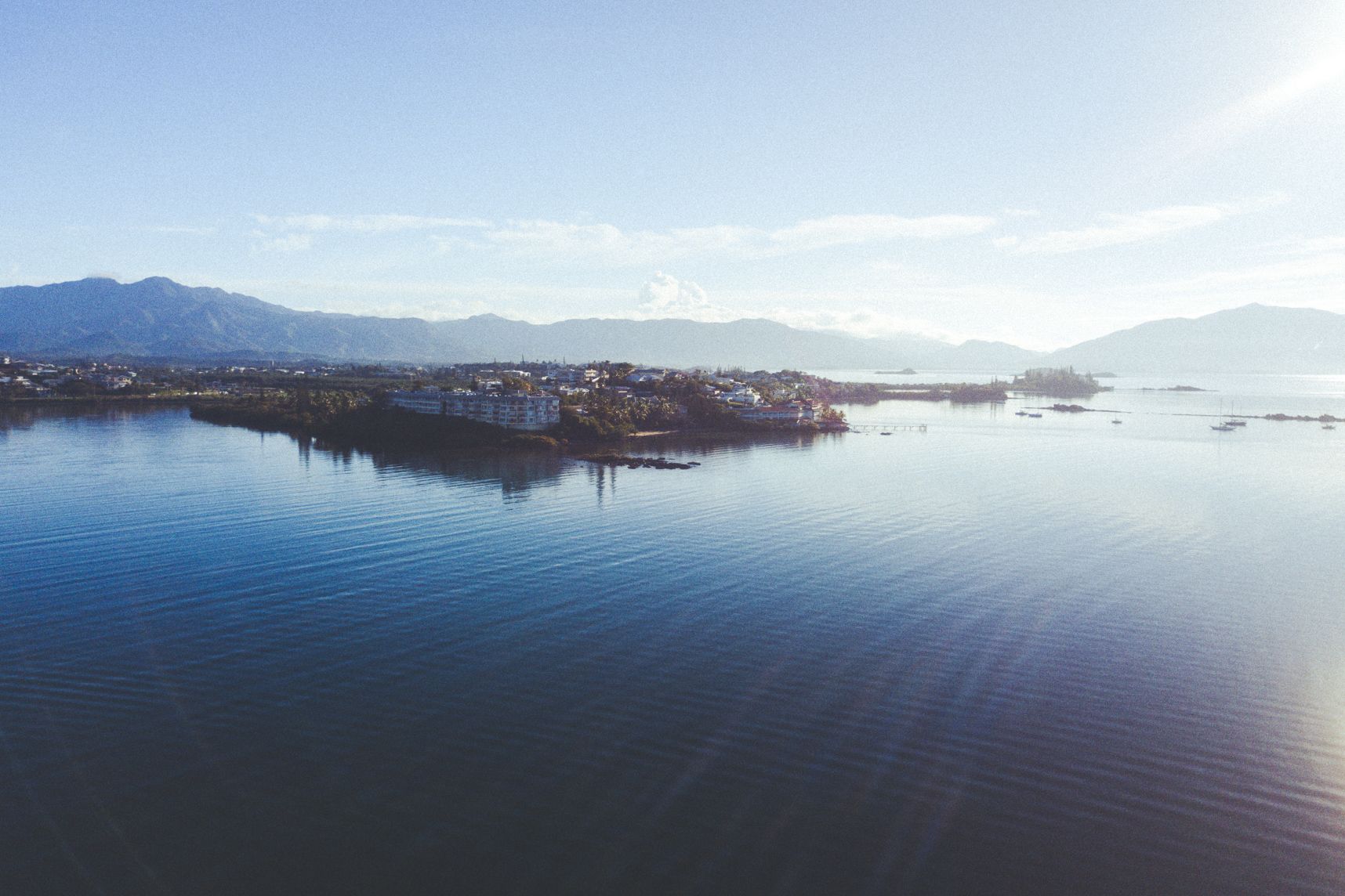 Au lever de soleil, la mer est d'huile. Le paysage montagneux y reflète.