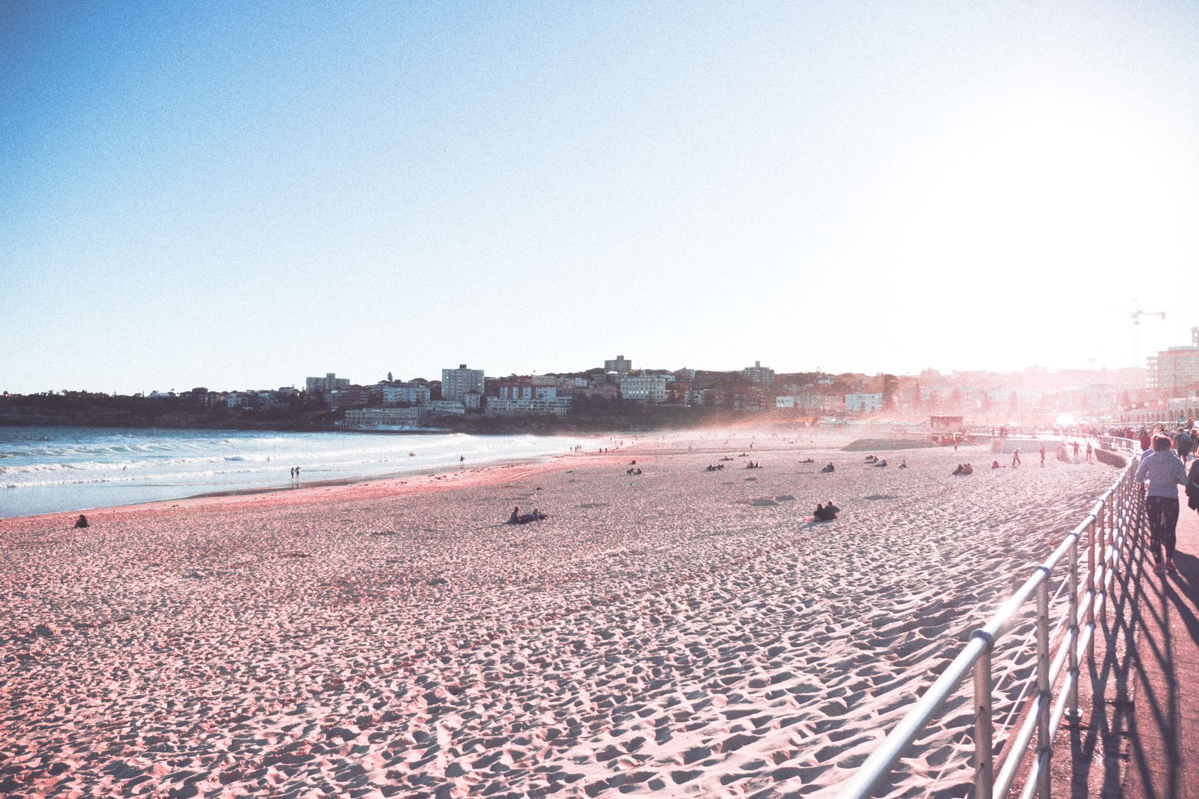 Le soleil se couche sur la plage de Bondi, beaucoup de vent ce jour là, on voit l'embrun et le sable à travers les rayons du soleil 