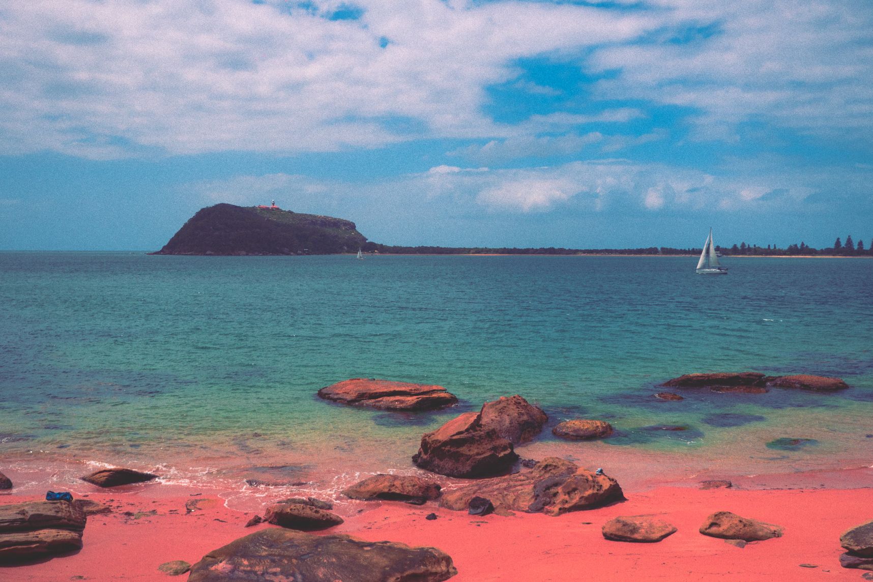 De l'autre côté du rivage on voit le phare de Palm Beach en haut de son rocher